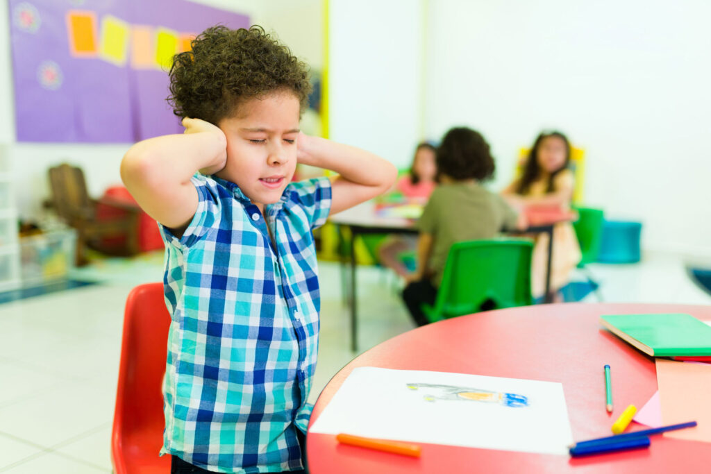 upset preschool boy covering ears